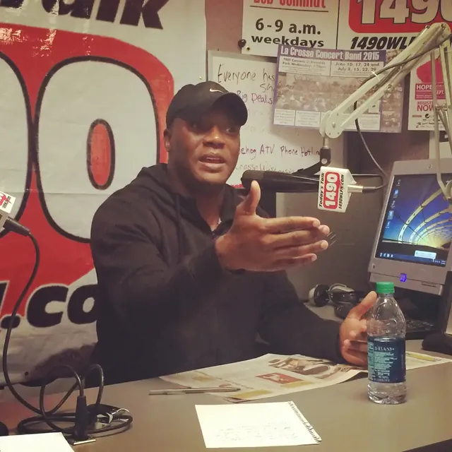 Kevin speaking into a microphone in a radio studio